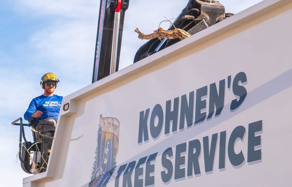 Kohnen's Tree Service grapple truck loading cut tree limbs and debris for hauling